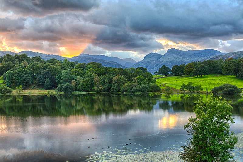 loughrigg-tarn-sun-setting-over-langdale-pikes-with-loughrigg-tarn-in-foreground