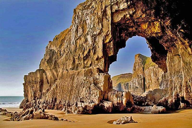 manorbier-bay-blow-hole-forming-a-rock-archway-beneath-the-towering-pembroke-coastline-between