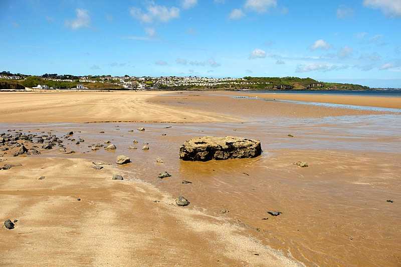 benllech-beach-a-view-from-a-stream-and-rocks-across-the-deserted-clean-sandy-beach-to-the-holiday