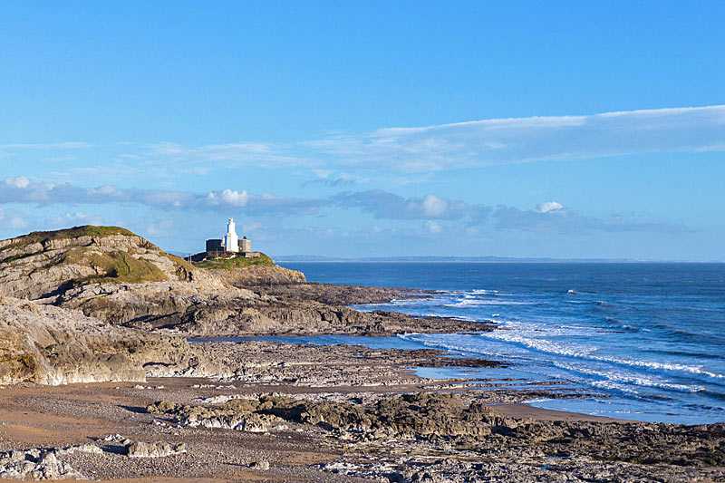 bracelet-bay-beach-mumbles-lighthouse-seen-across-bracelet-bay-on-the-south-wales-coast-path-in-the